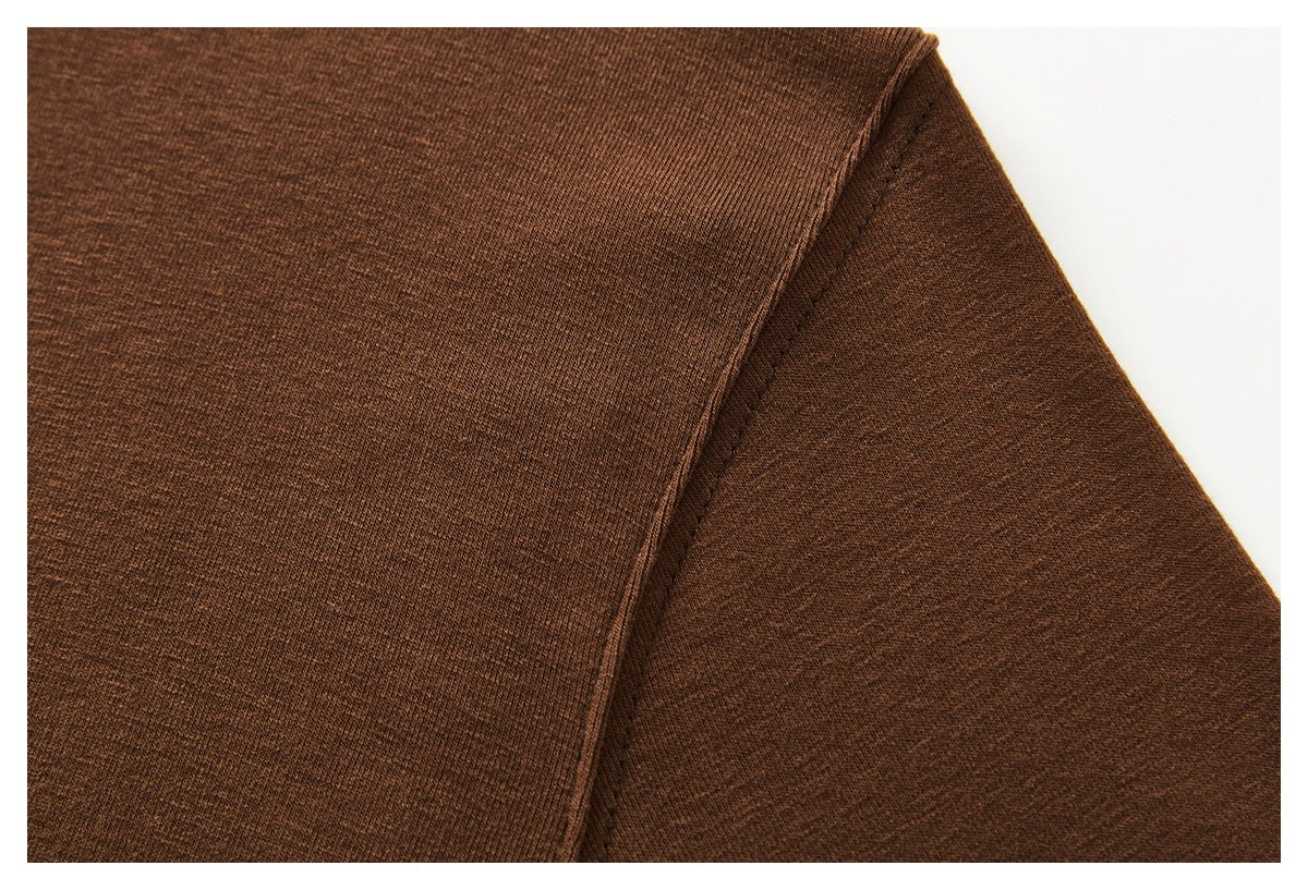 Close-up of brown knit garment fabric with a diagonal stitched seam.