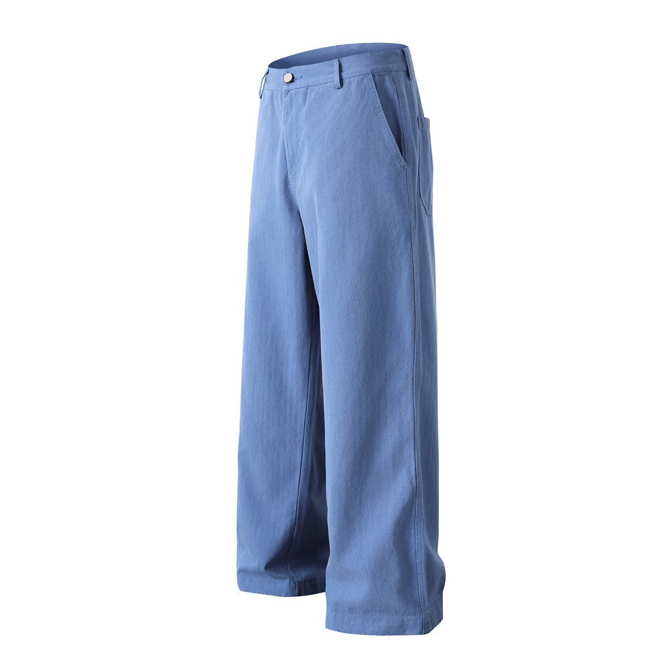 Blue wide-leg trousers shown at an angle, with a button waistband, angled pockets and full-length hems.