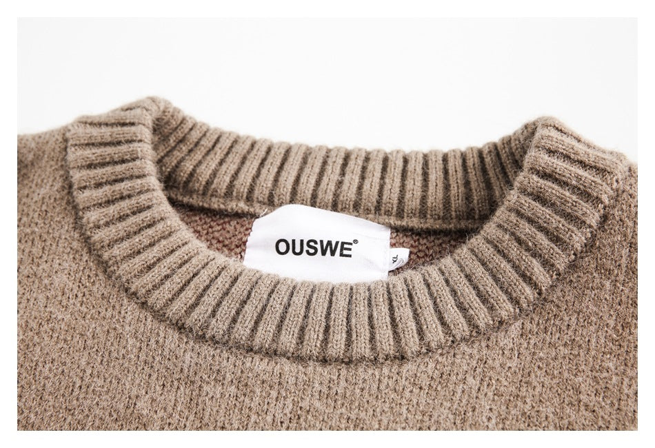 Close-up of the sweater's ribbed taupe neckline and sewn-in white brand label.