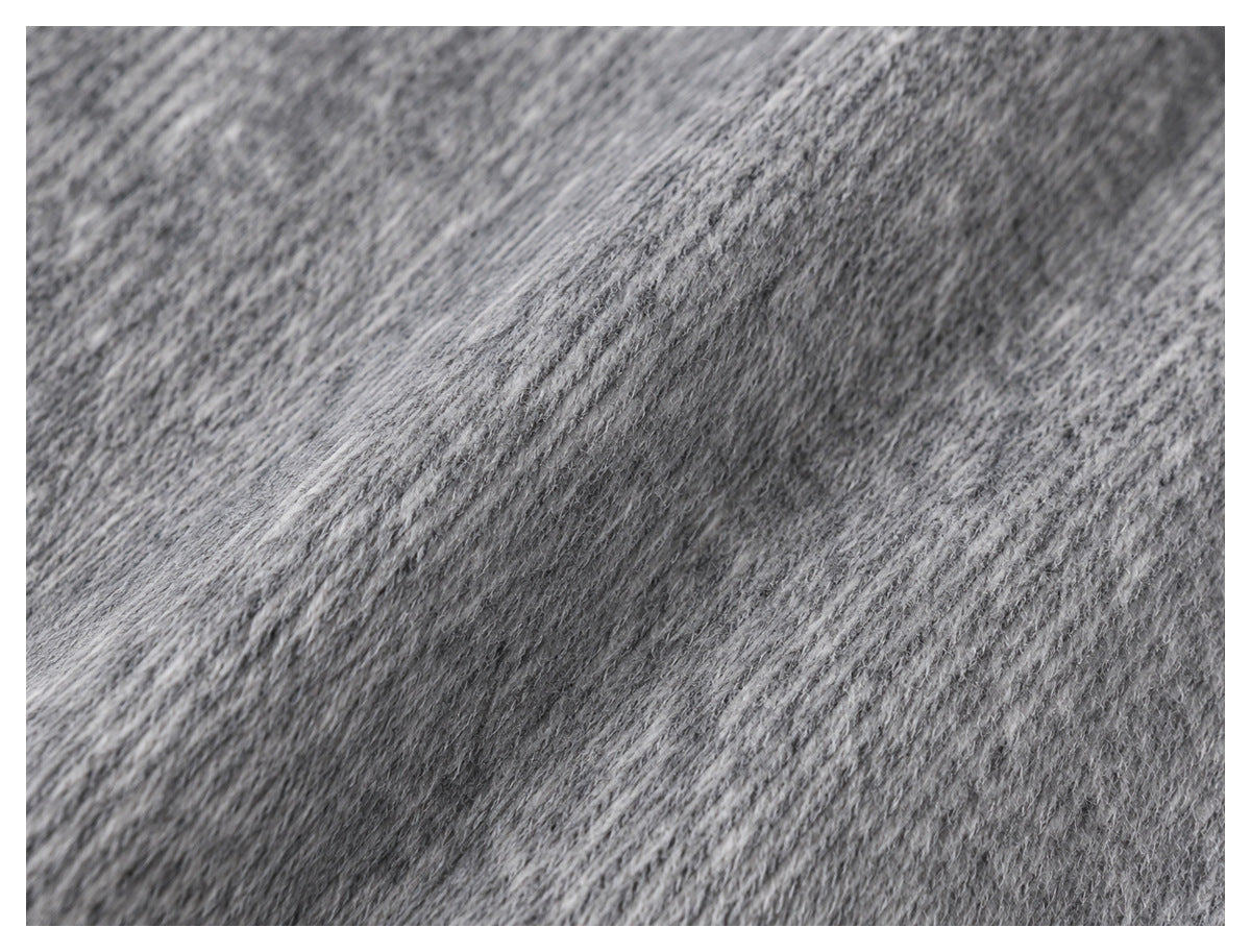 Close-up of gray fabric showing a soft, mottled surface and fine diagonal knit texture.