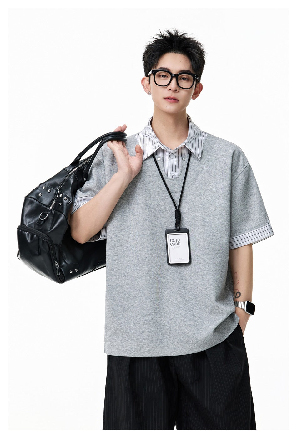 Model wearing the gray striped-collar short-sleeve top with black pinstripe pants, holding a black bag