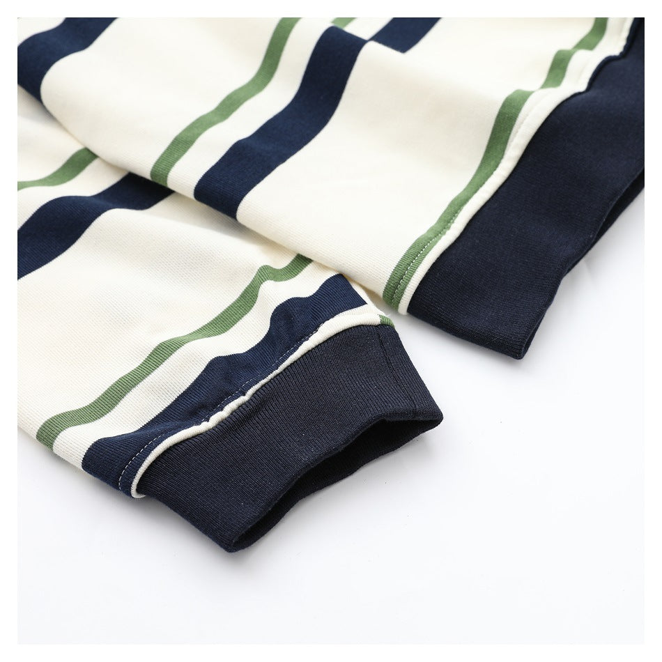 Close-up of the shirt's navy ribbed cuffs beside ivory fabric with navy and olive stripes.