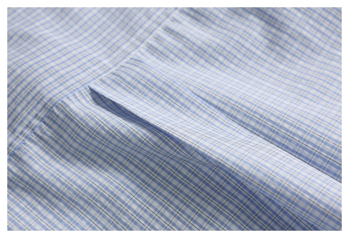 Close-up of the chest pocket on a blue-and-white checked shirt.