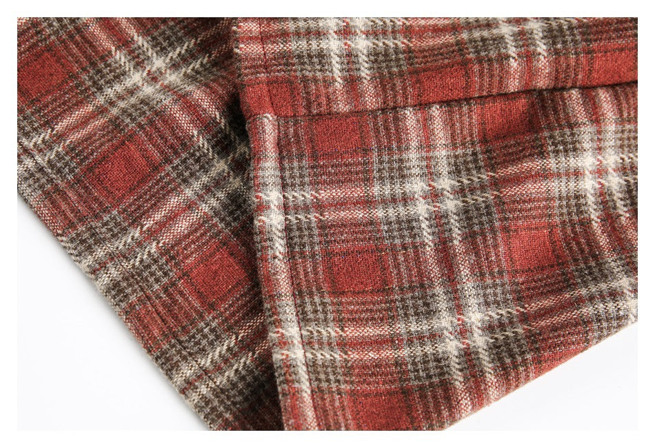 Close-up of the plaid shirt hem and seam in red, brown, and cream checks.
