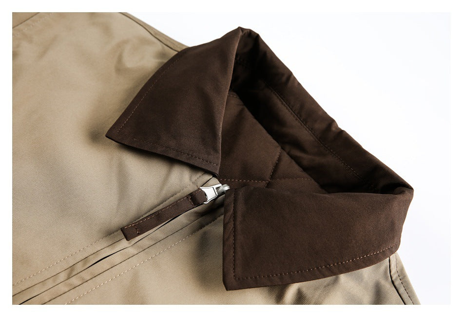 Close-up of a tan garment with a dark brown collar and lining beside a short zipper and fabric tab.