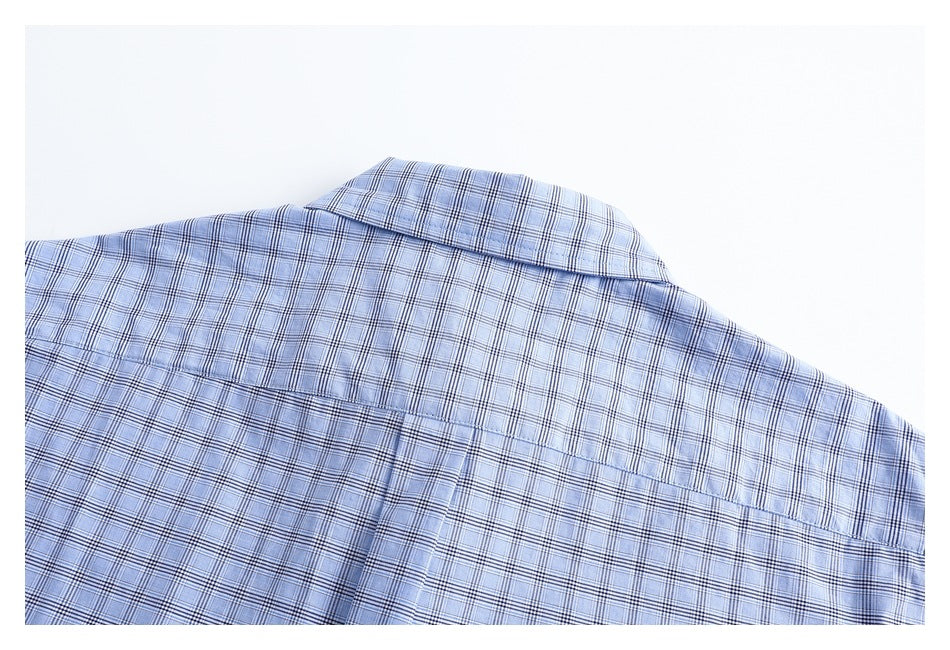 Close view of the back yoke and collar of a light blue plaid shirt.