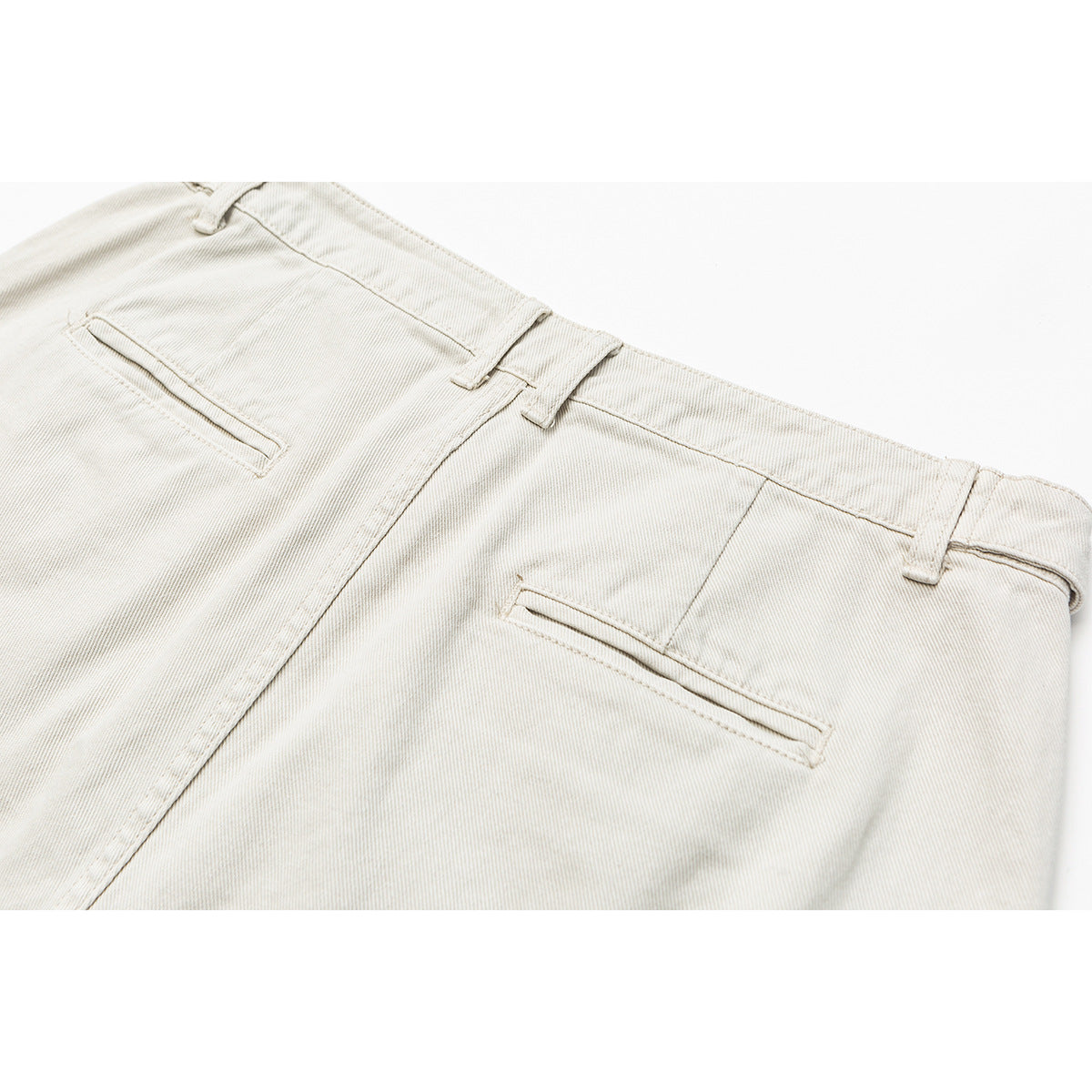 Close-up of the back waistband and welt pockets of off-white shorts.