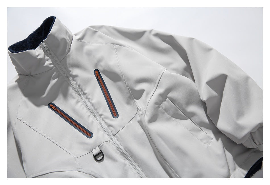 Front view of a light gray jacket laid flat, with a high dark-lined collar, center zipper, and orange-accented zip pockets.