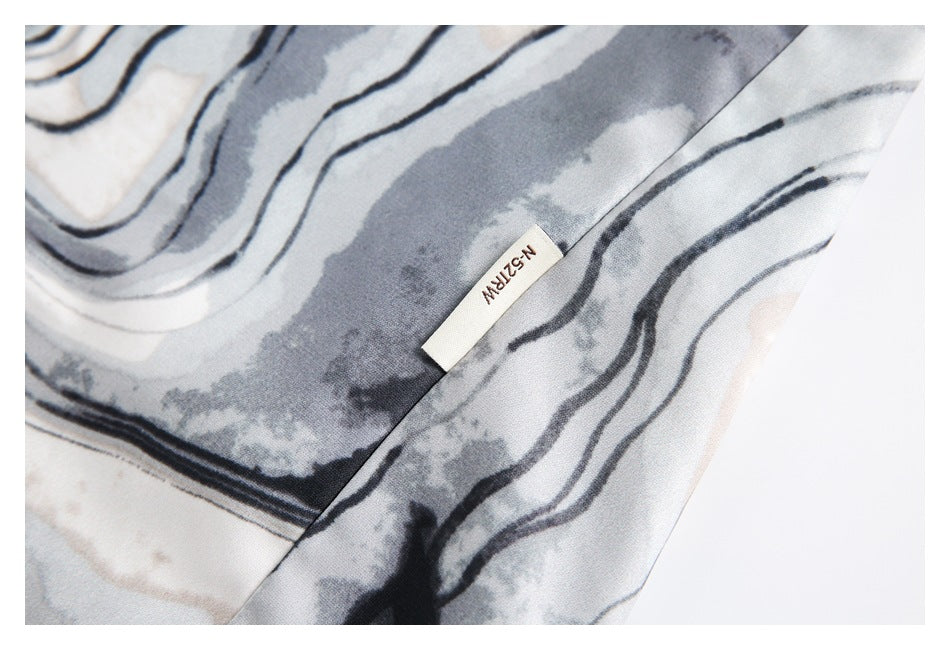 Close-up of gray and off-white abstract-patterned fabric with a small sewn label.