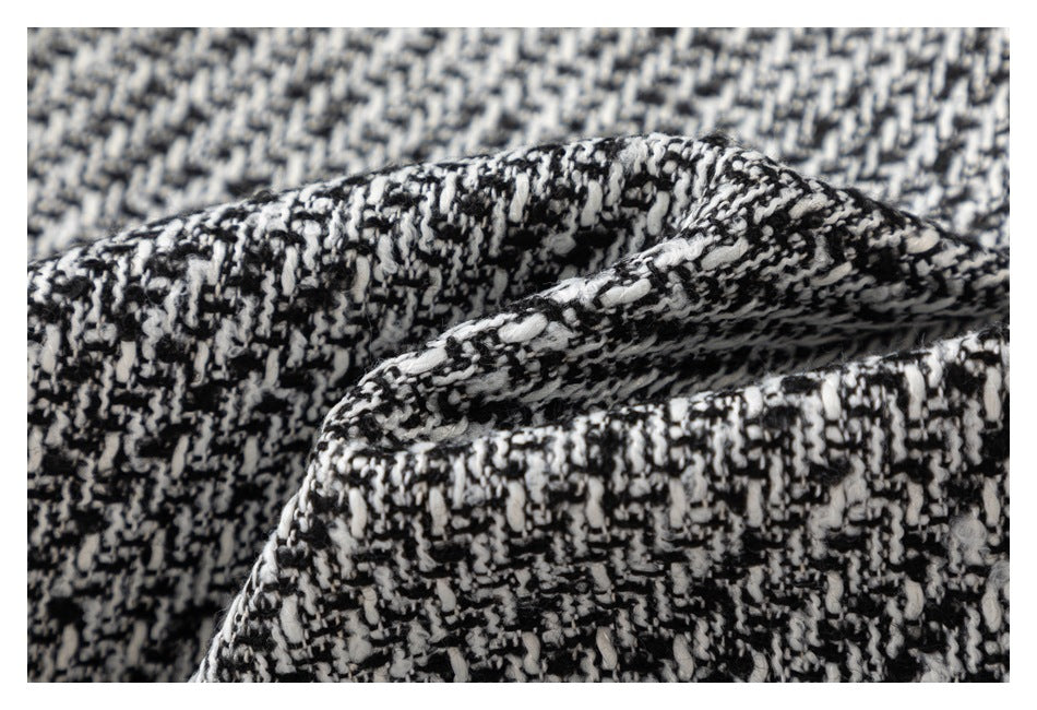 Close-up of black-and-white textured woven fabric with a folded edge.