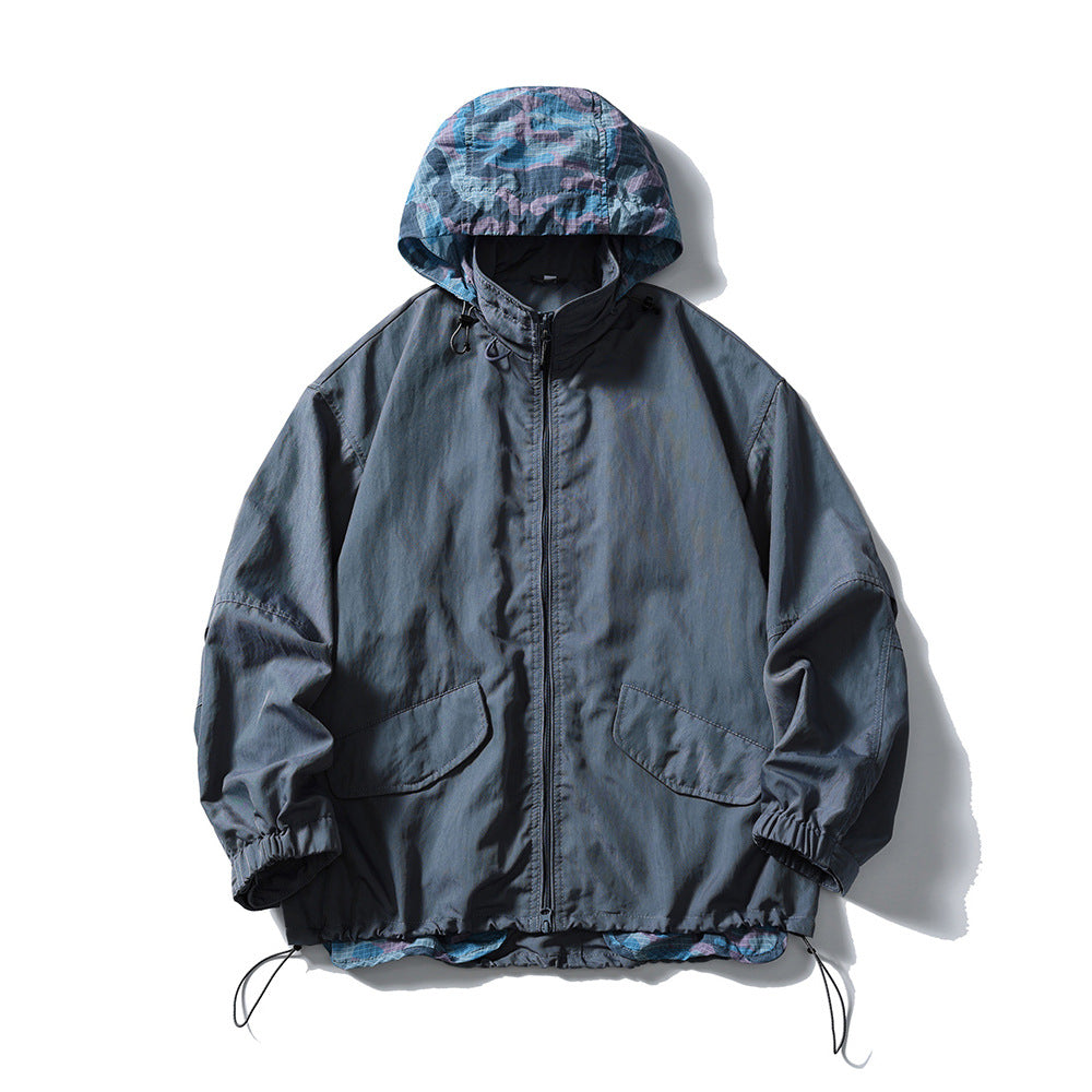 Blue hooded zip jacket with blue and pink camouflage hood lining, flap pockets and drawcord hem, flat lay