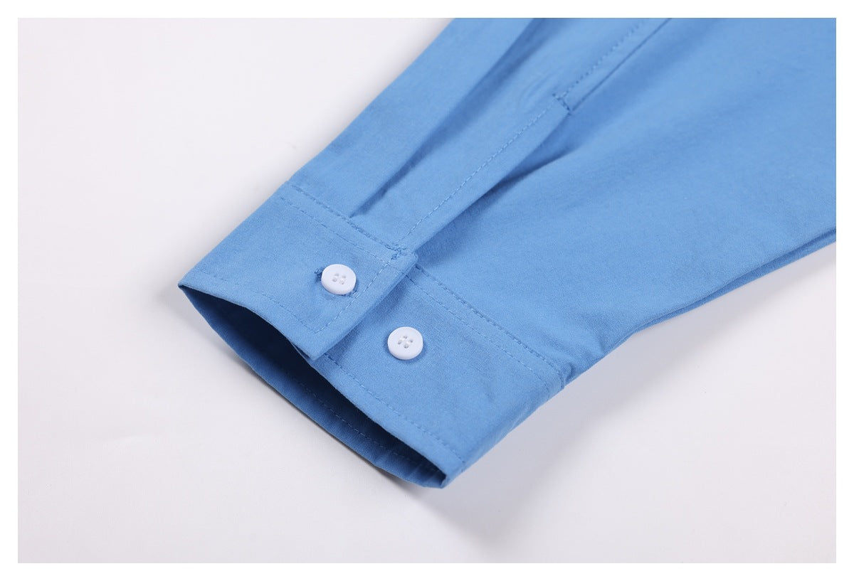 Close-up of a blue shirt cuff with two white buttons and stitched edges.