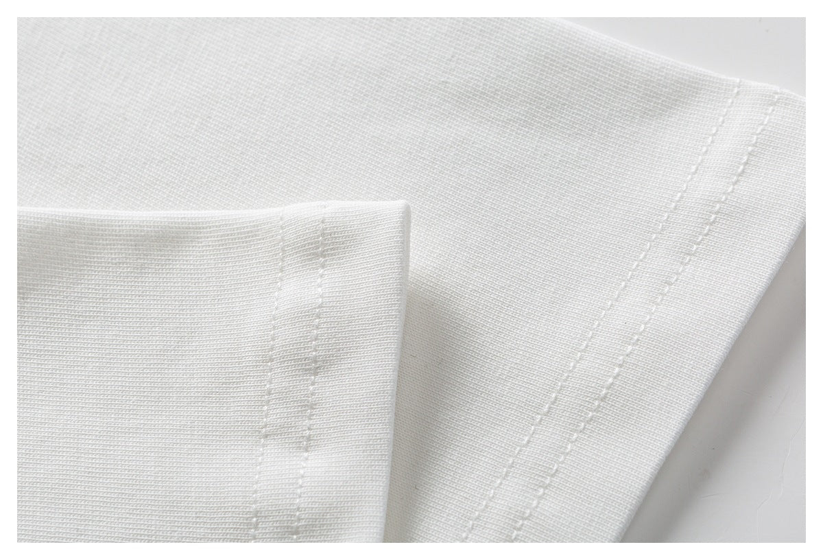 Close-up of white T-shirt fabric and double-stitched seam finishing.