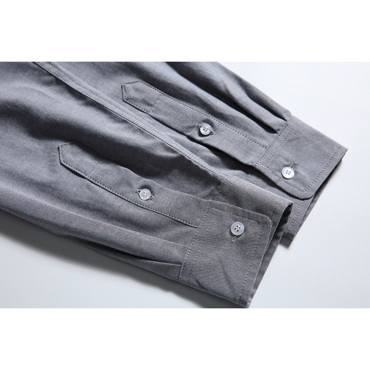 Close-up of the gray shirt's buttoned cuffs and sleeve plackets.