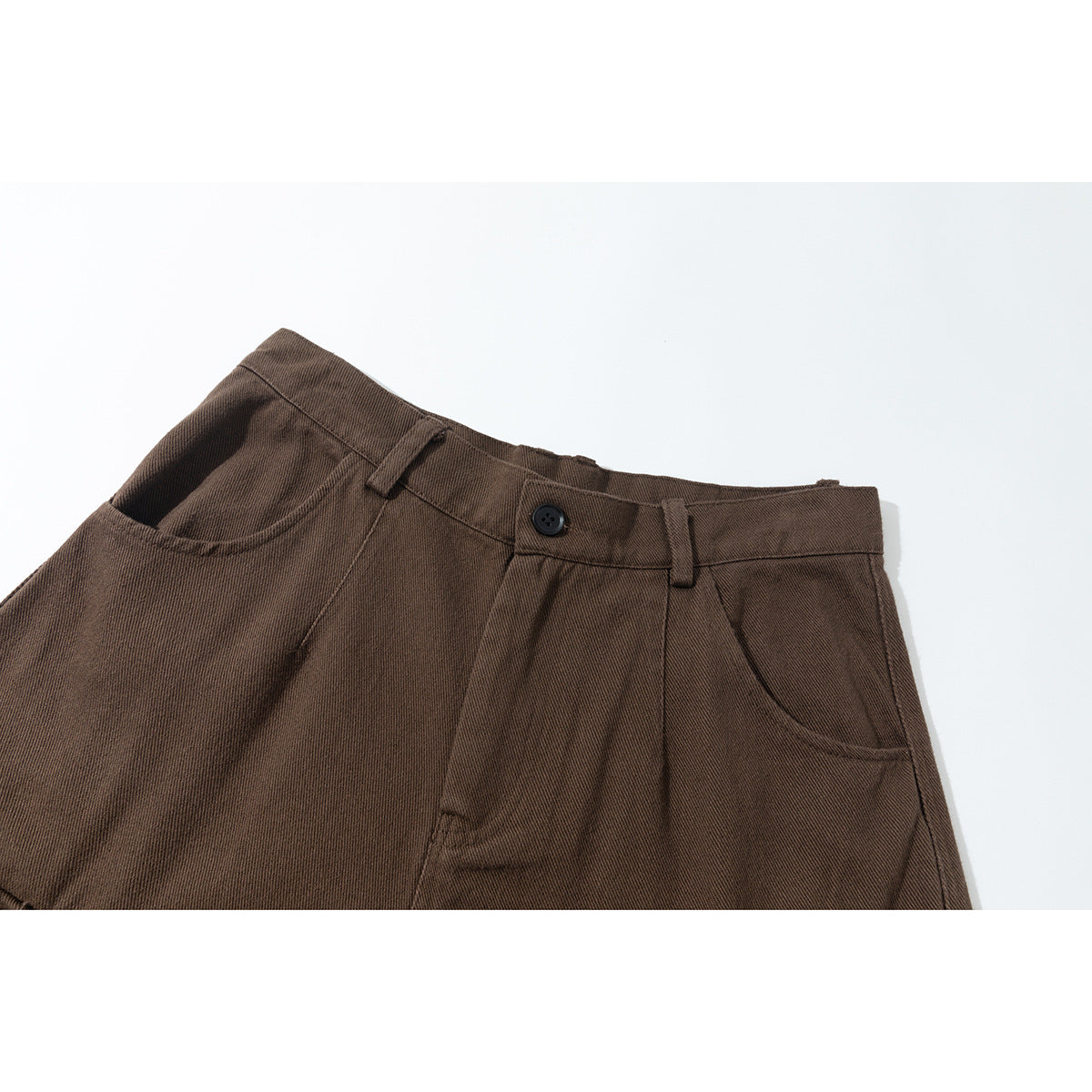 Close-up of brown cargo pants showing the waistband, button, belt loops, pleats, and front pockets.