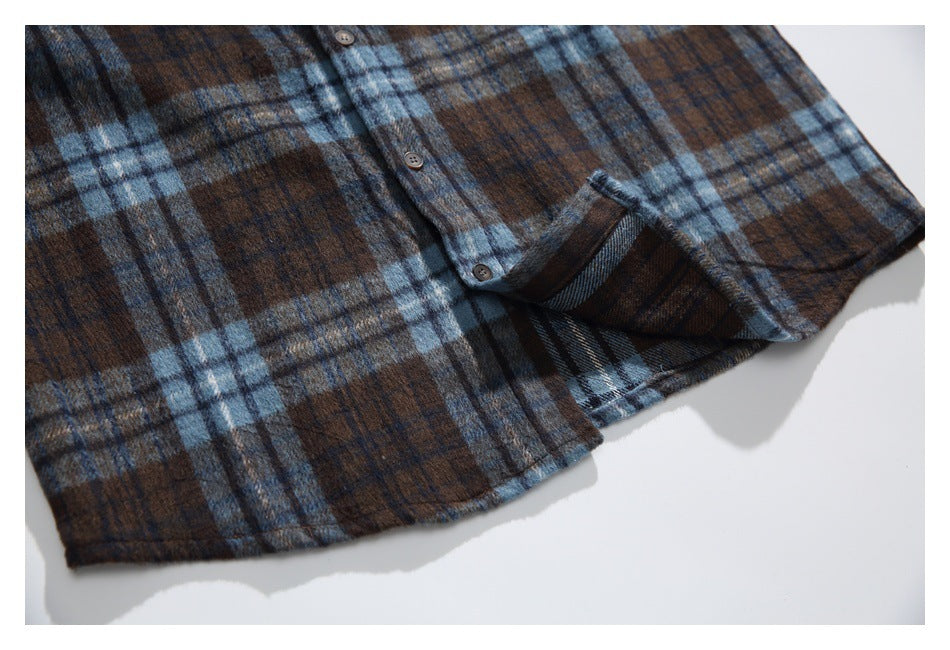 Close-up of the shirt's plaid lower hem and button placket, with a folded section revealing the reverse.