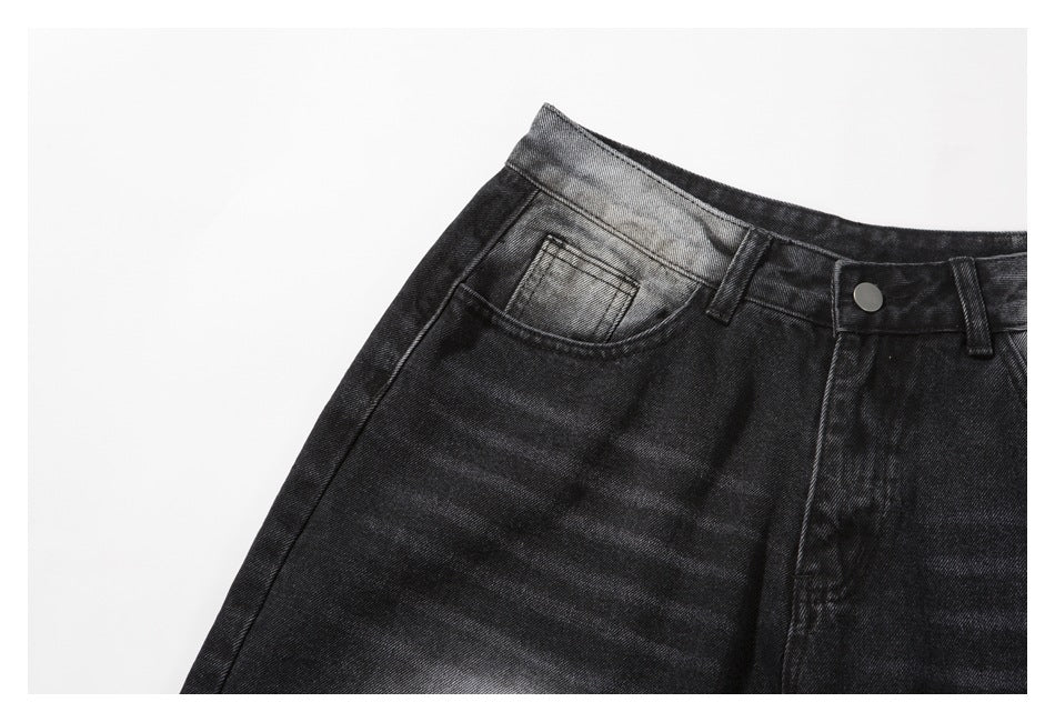 Close-up of the left front pocket and waistband on charcoal-black denim shorts with a faded wash.