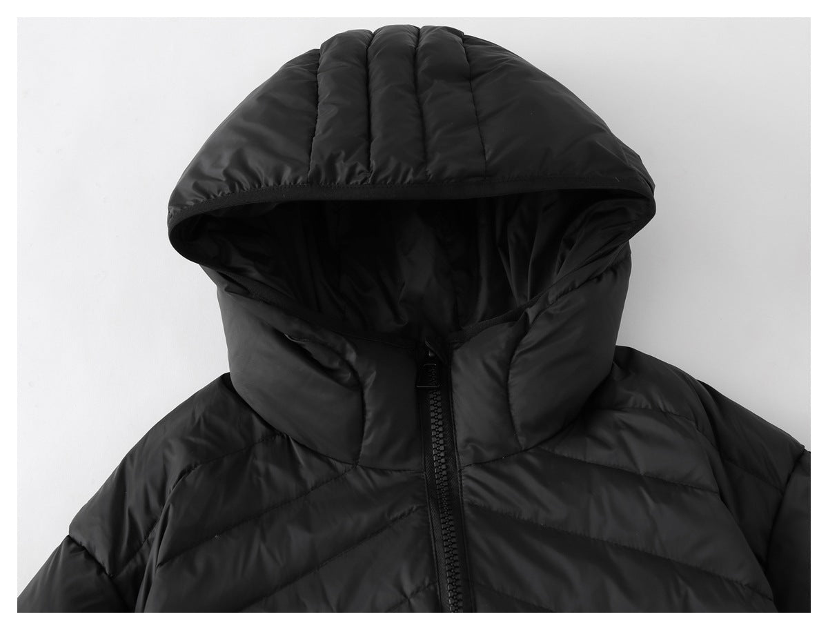 Close-up of a black quilted jacket's padded hood, high collar and front zipper.
