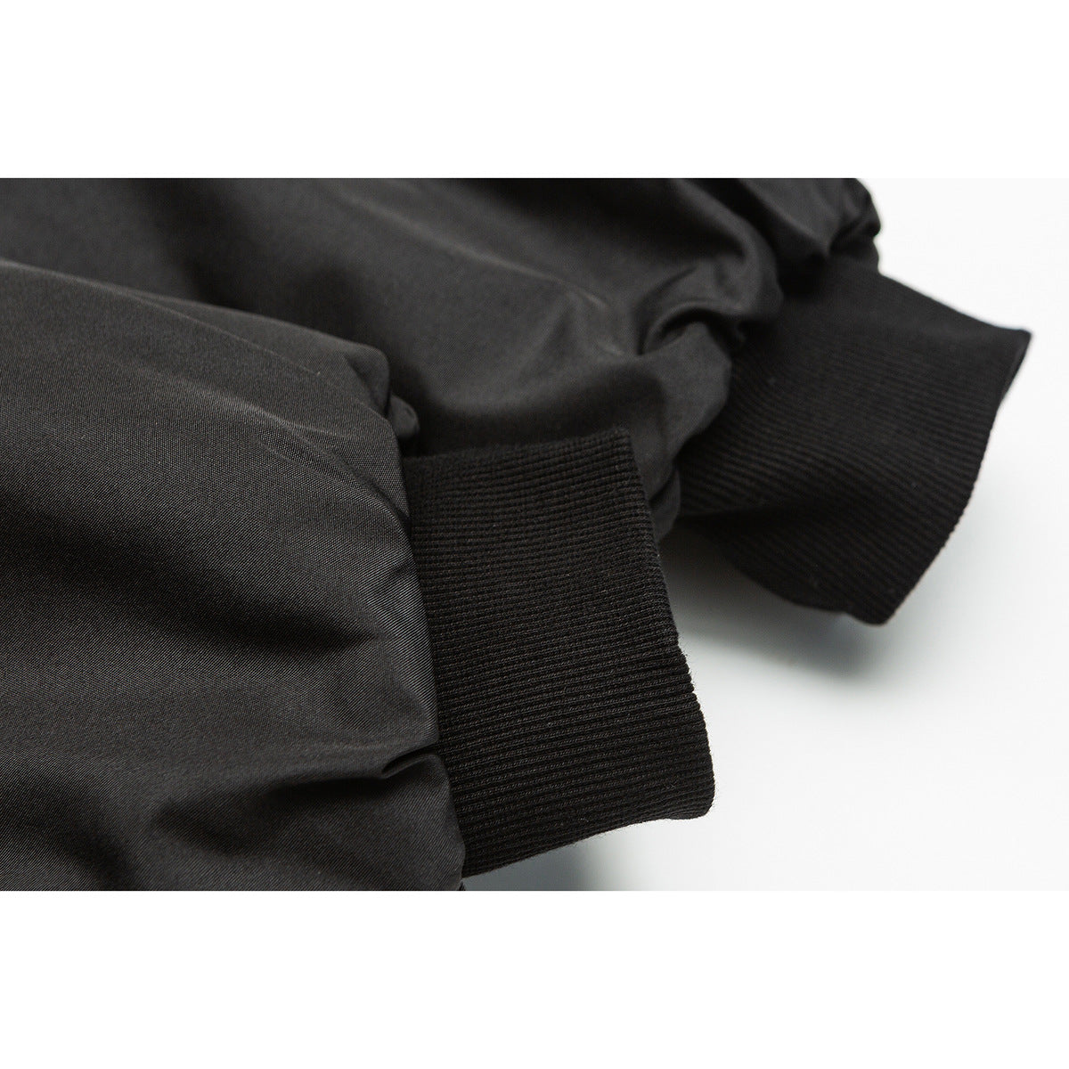 Close-up of a black jacket sleeve and wide ribbed cuff.