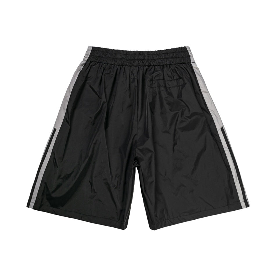Back view of black shorts with gray side panels, black stripes, elastic waist and small back pocket