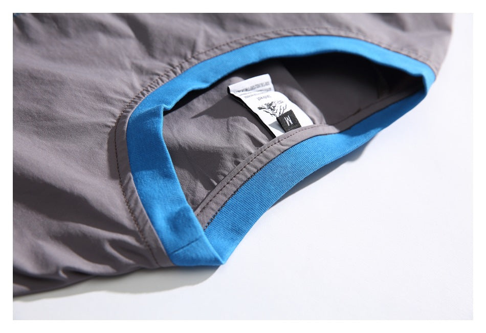 Close-up of a gray garment opening with bright blue trim and sewn-in labels.