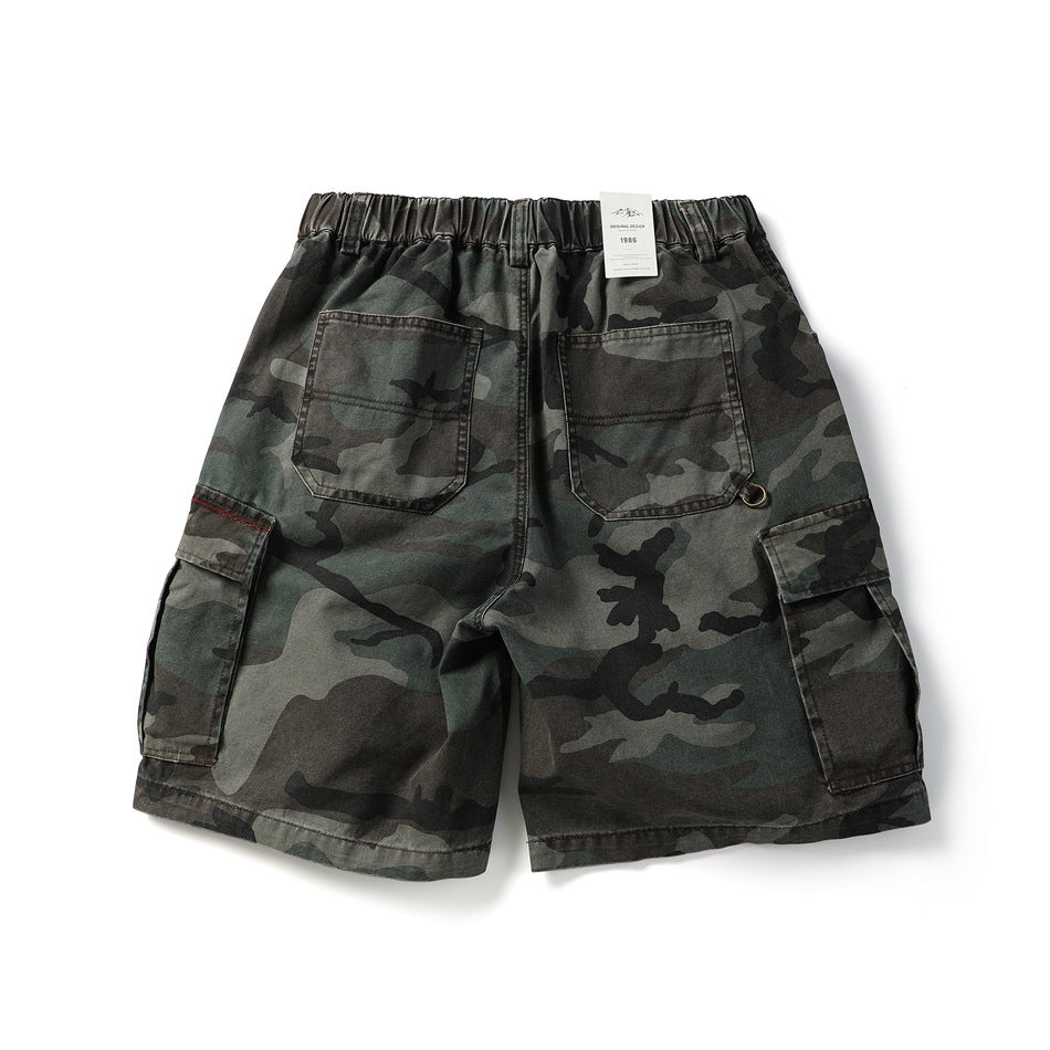 Back view of dark green camouflage cargo shorts with an elastic waist, two rear pockets and side cargo pockets.
