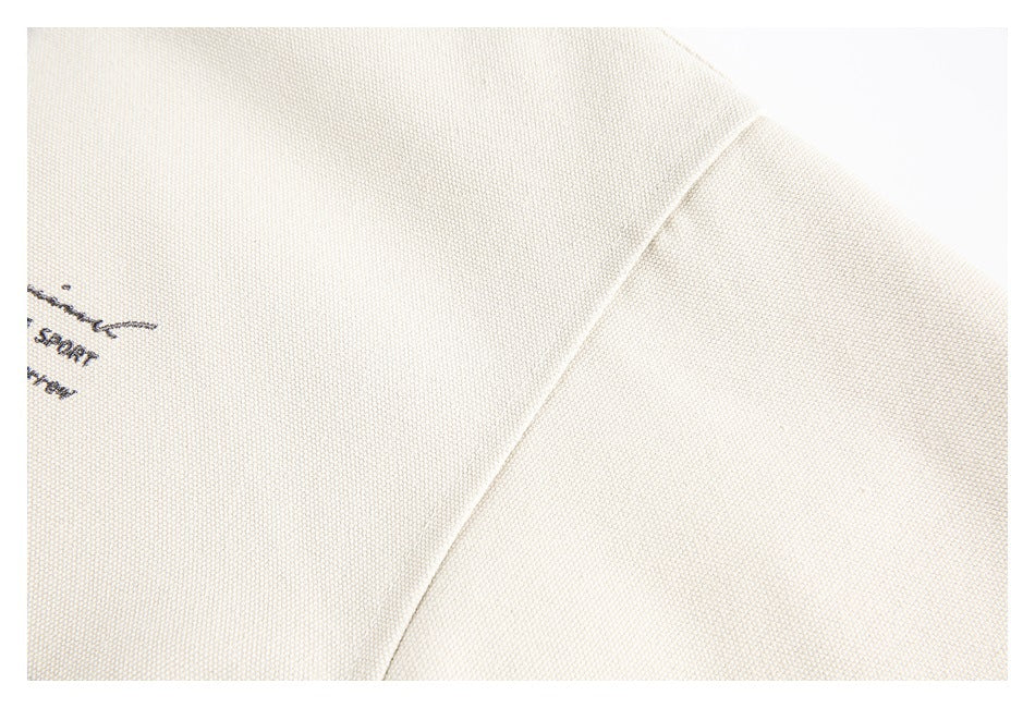 Close-up of cream textured fabric showing a curved seam and adjoining panel.