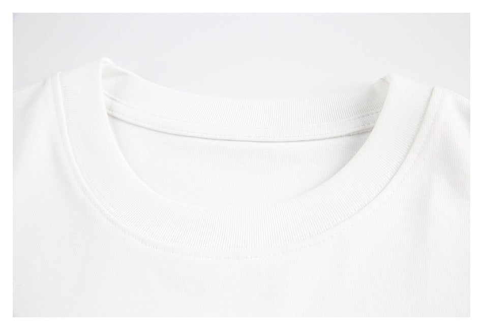 Close-up of the ribbed crew neckline and stitching on a white T-shirt.