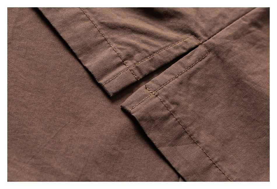Close-up of brown garment fabric showing overlapping folded edges and intersecting stitched seams.