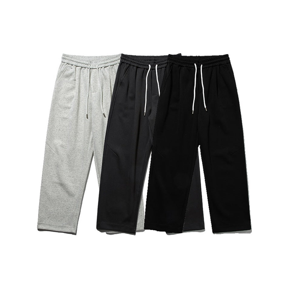 Three pairs of relaxed drawstring pants shown from the front in light gray and black.