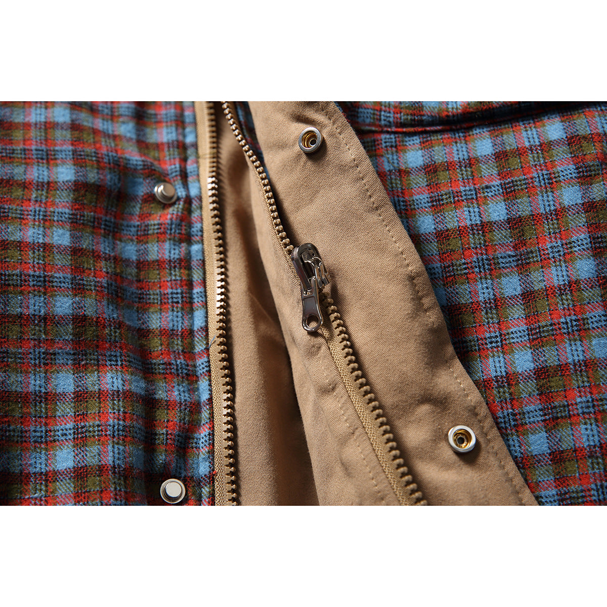 Close-up of the plaid jacket's tan inner placket, zipper, and metal snap fasteners.