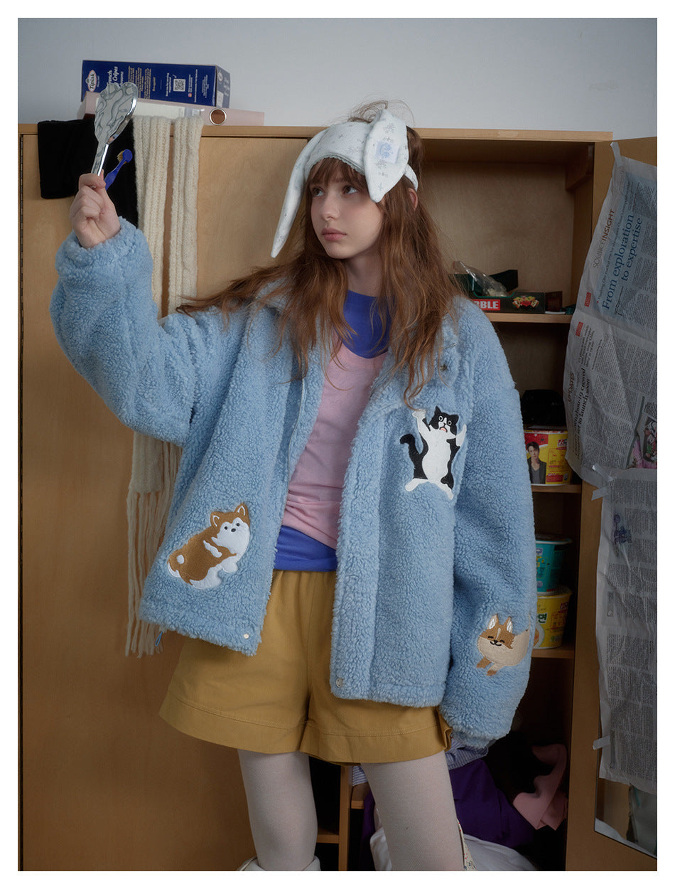 Closer front view of a model wearing a light blue plush jacket with cat and dog appliqués.