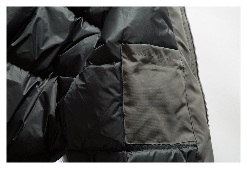 Close-up of a rectangular pocket on the black lining inside a dark olive jacket.