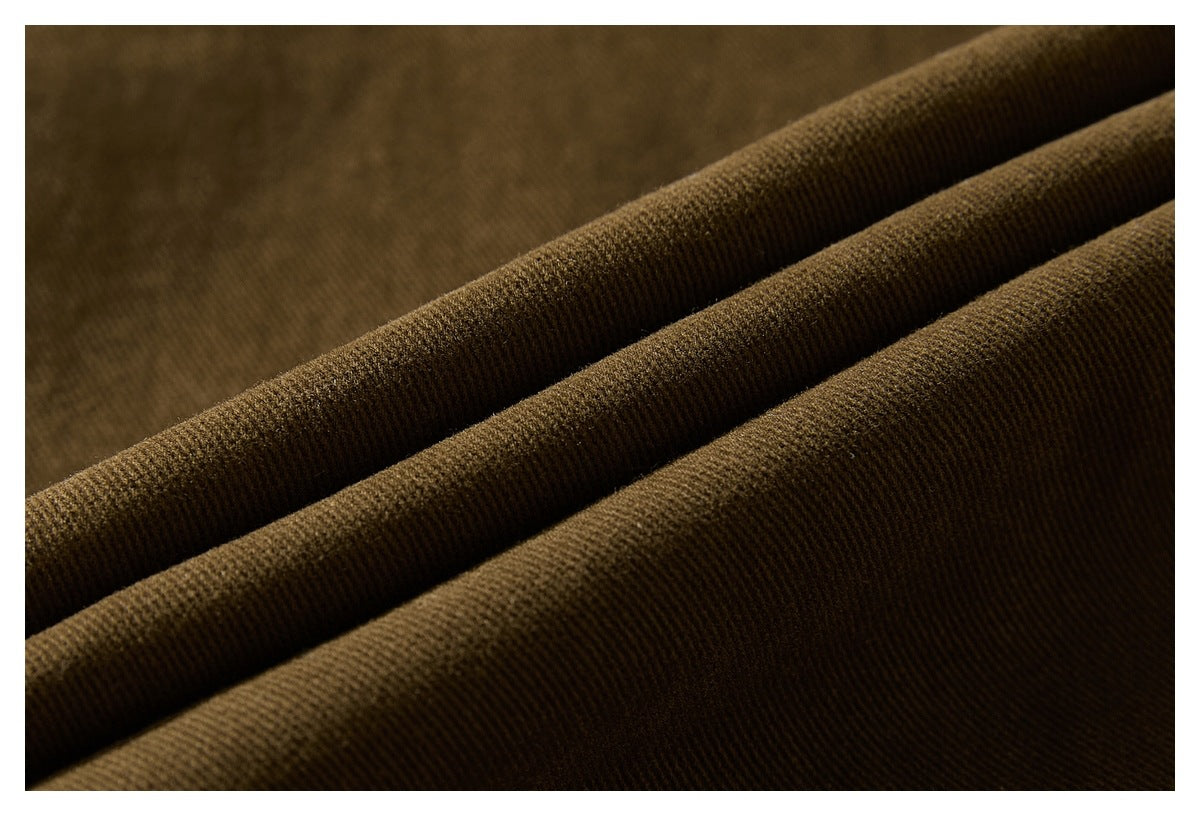 Close-up of dark brown fabric gathered into diagonal folds, showing its fine ribbed texture.