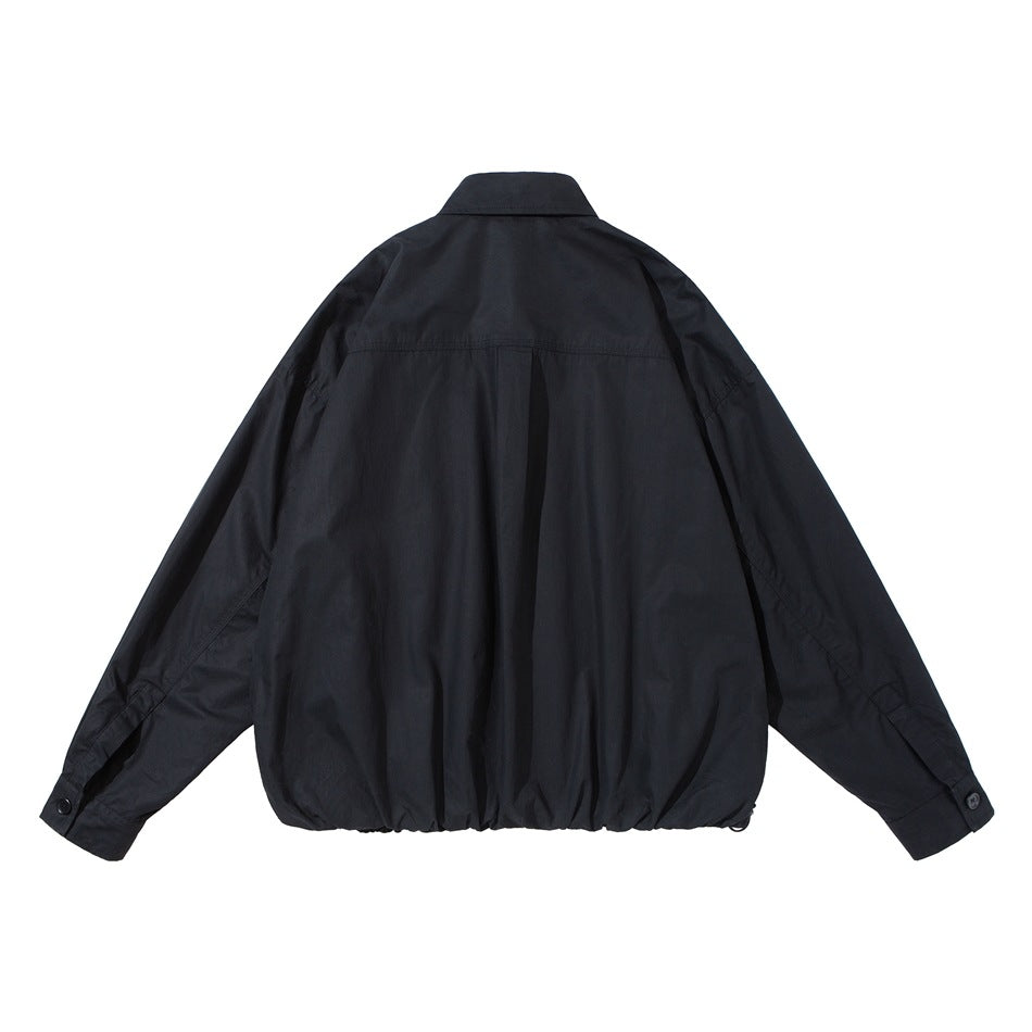 Back view of black shirt-style jacket with back yoke seam, button cuffs and gathered drawstring hem
