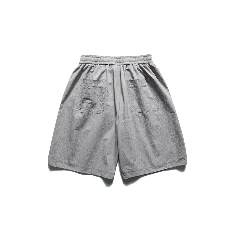 Back view of light gray shorts with an elastic waistband and two patch pockets.