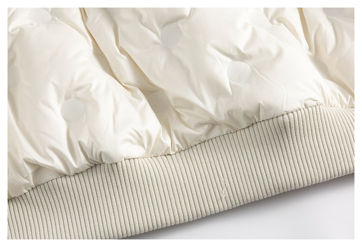 Close-up of the cream jacket's gathered lower edge and wide ribbed knit hem.