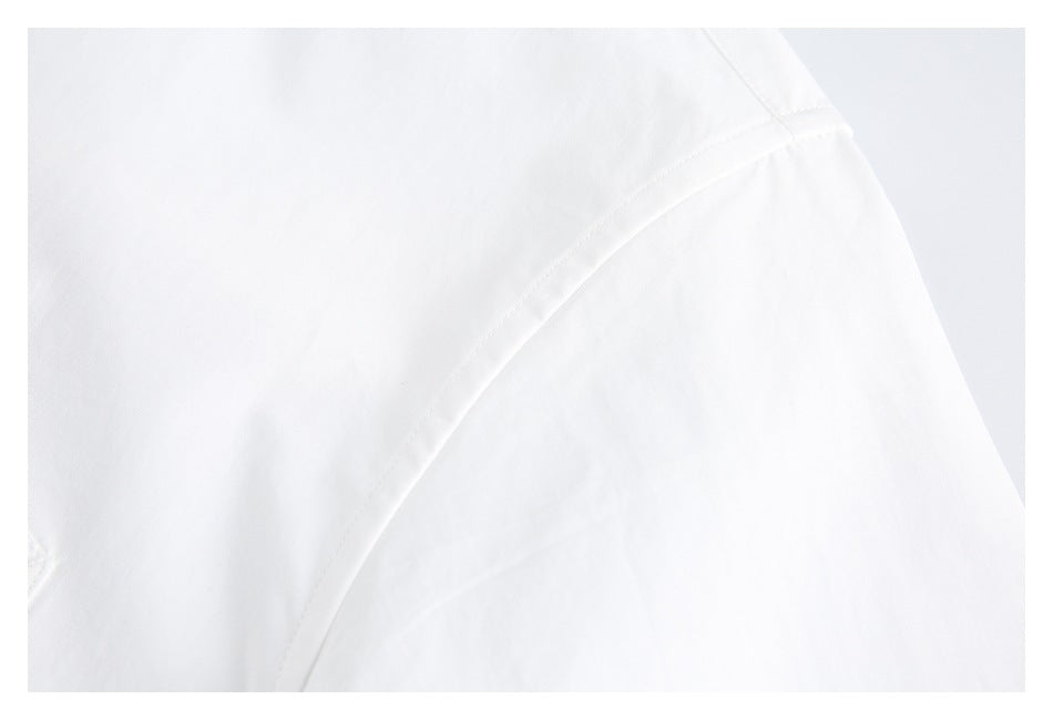 Close-up of a curved stitched seam on white garment fabric.
