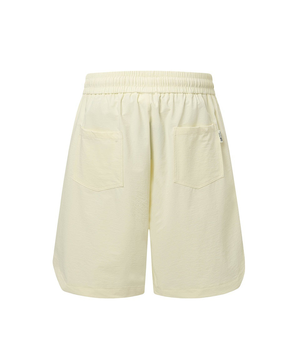 Cream shorts back view with elastic waistband, two patch pockets and a small woven label