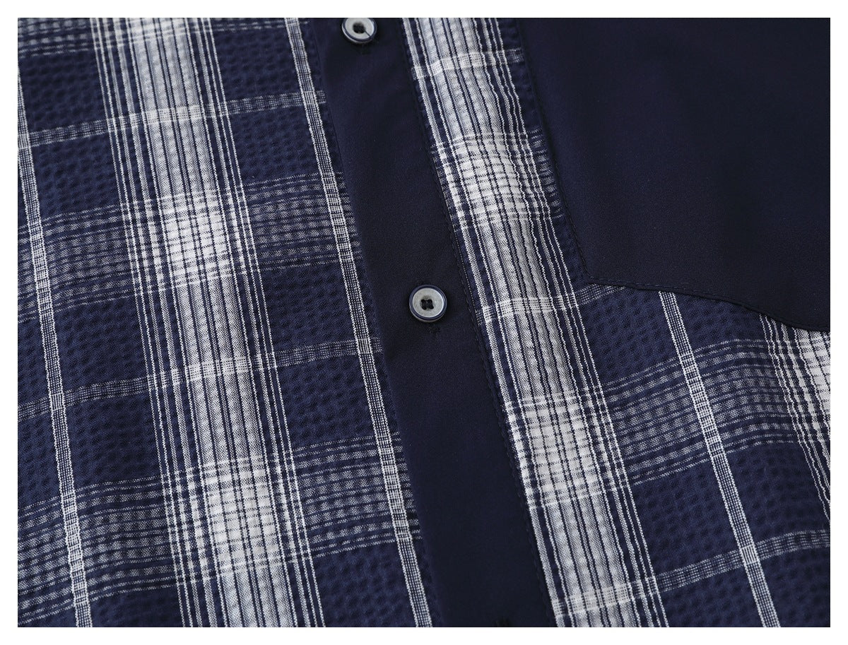 Close-up of a navy-and-white plaid shirt front with a solid navy button placket and pocket.