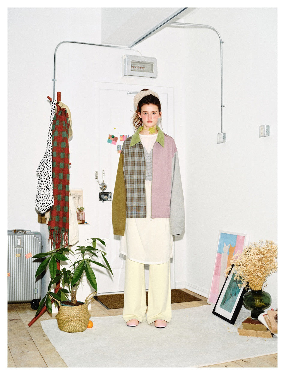 Front view of a model wearing a color-block jacket with a gray-brown plaid panel, green collar, mauve panel, and contrasting