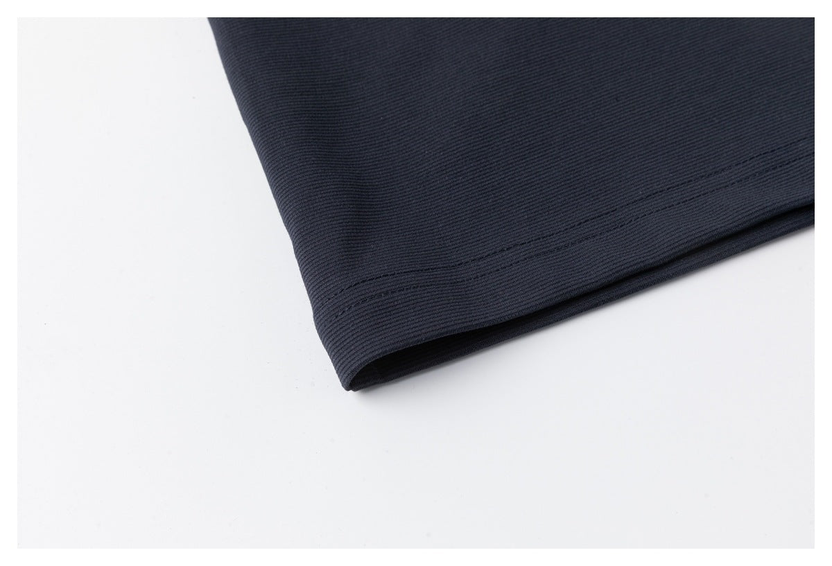 Close-up of the navy polo's bottom hem with parallel stitching.