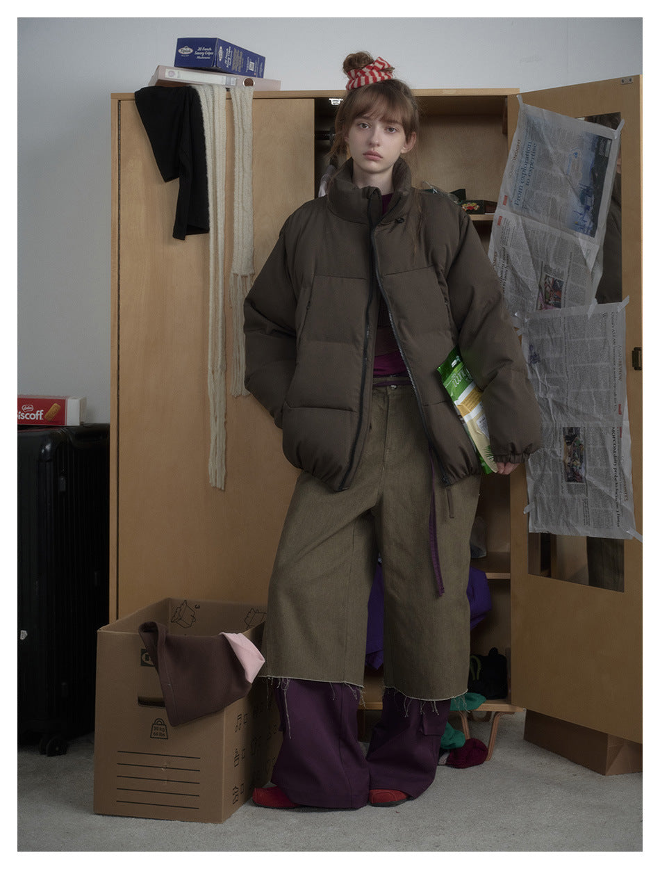 Full-length view of a model wearing a dark brown puffer jacket with a high collar and zip front.