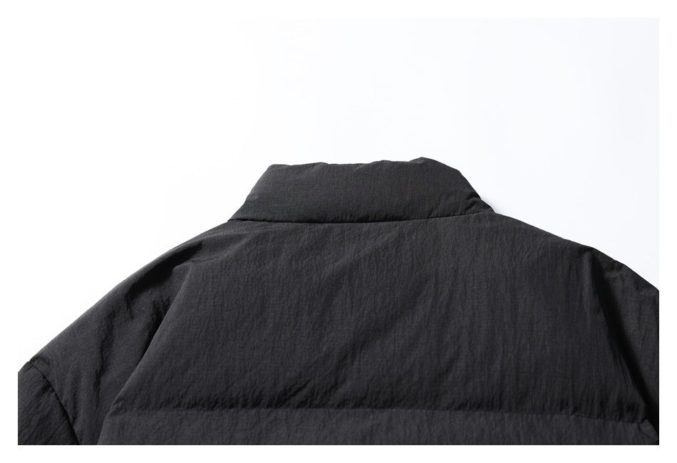 Partial rear view of a black jacket, showing its raised collar and upper back.