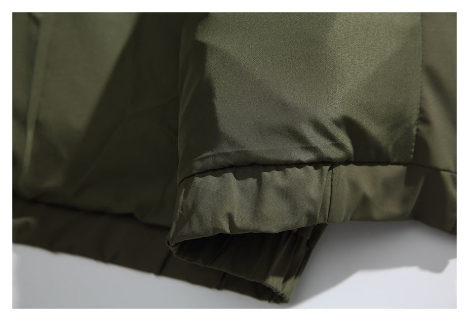 Close-up of an olive jacket’s gathered elastic edge and stitched hem.