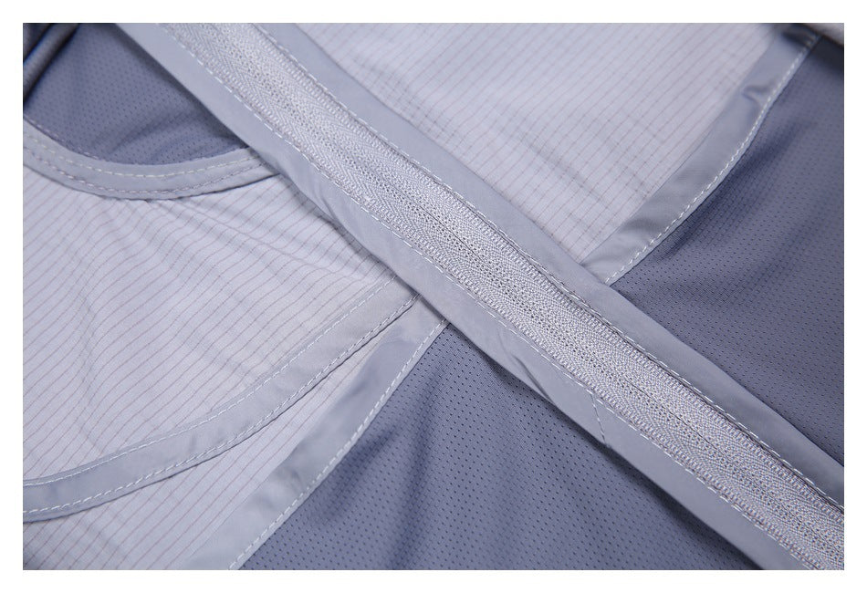 Close-up of blue-gray garment panels, stitched trim, and a long zipper.