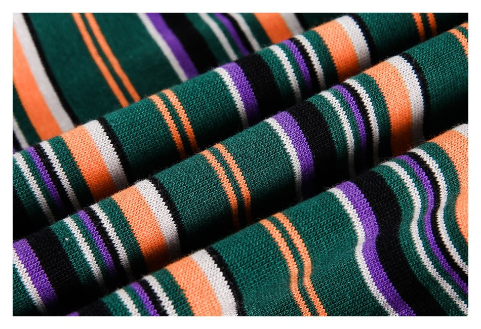 Close-up of striped dark green knit fabric with orange, purple, white, and black bands.