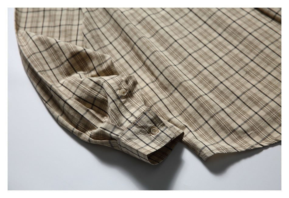 Beige plaid button-up shirt laid flat, showing the front, long sleeve, buttoned cuff, and curved hem.