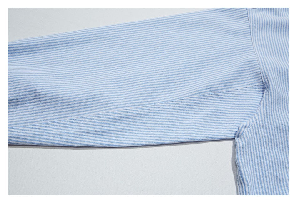 Close-up of a blue-and-white striped shirt sleeve and underarm seam.