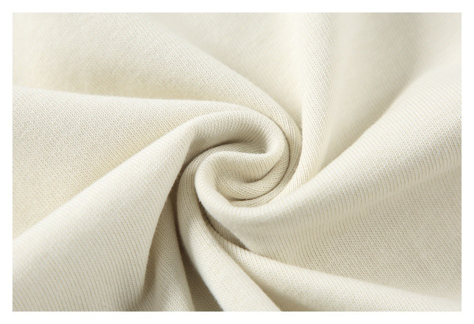 Close-up of cream fabric gathered into a spiral fold, showing its knit texture.